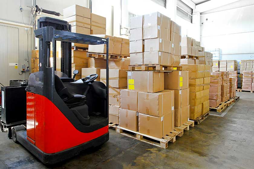 Red forklift in big warehouse with boxes
